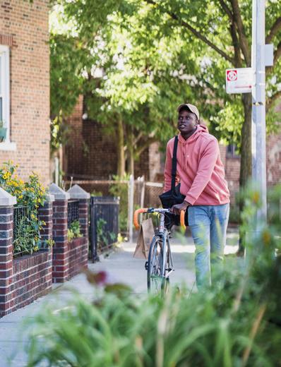 Jeune homme poussant un vélo