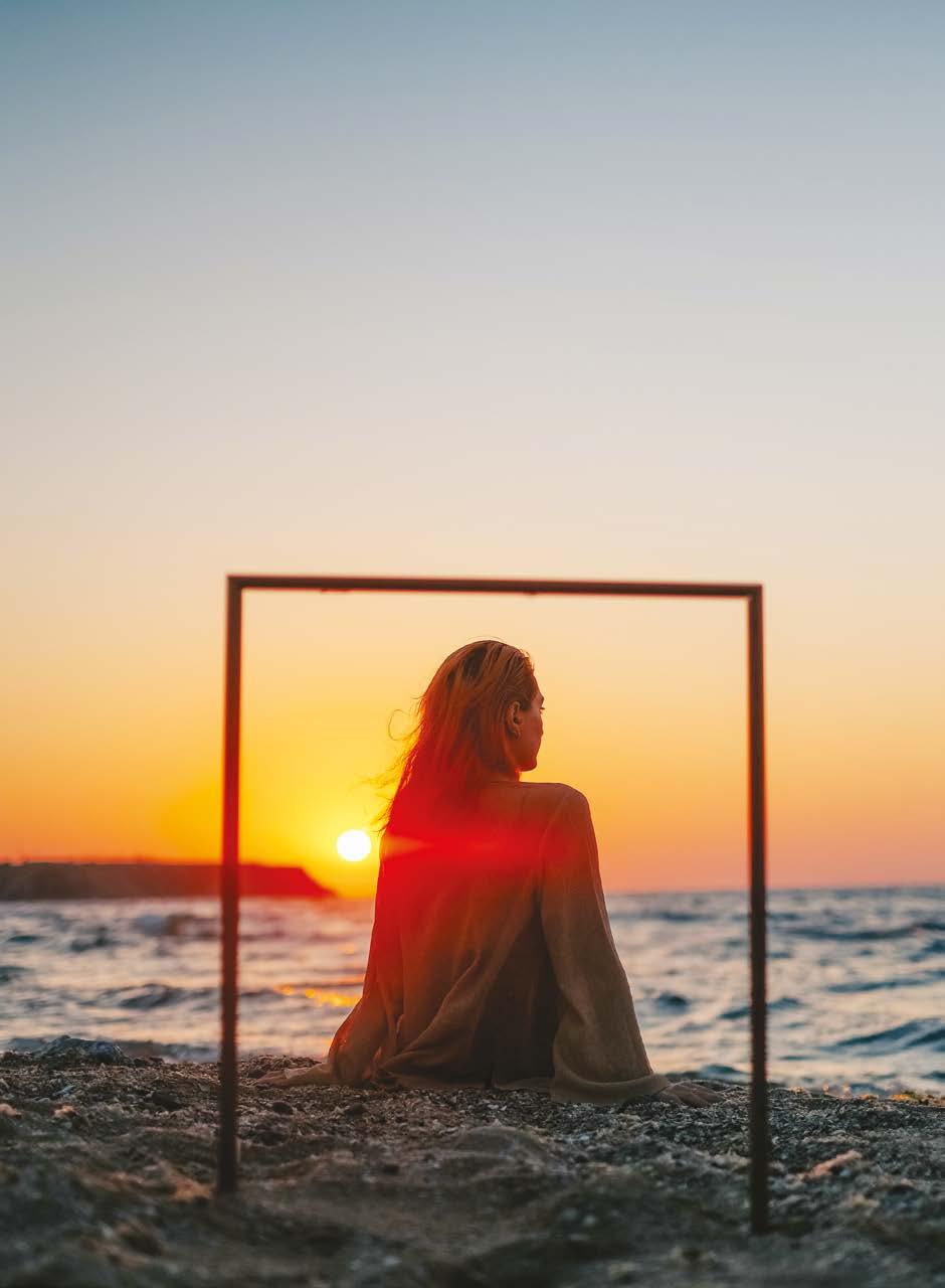jeune femme regardant un coucher de soleil